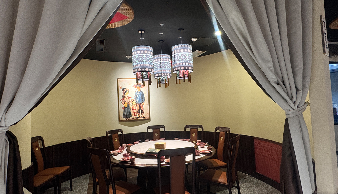 施锦记就餐环境:山货集市——包间圆桌与土家族人物画