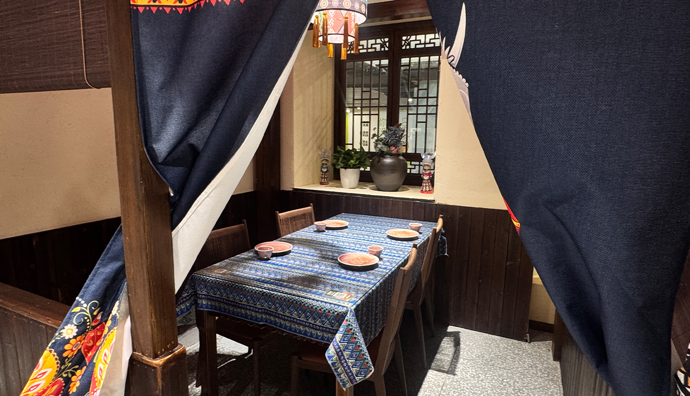 施锦记就餐环境:山货集市——包间织锦桌布与土家门帘